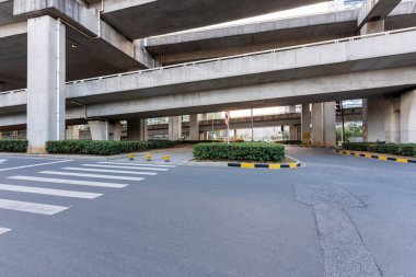 Şehirdeki üst geçidin altında beton yapı ve asfalt yol alanı