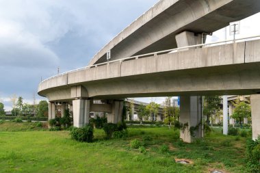 Şehirdeki üst geçidin altında beton yapı ve asfalt yol alanı