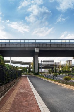 Şehirdeki üst geçidin altında beton yapı ve asfalt yol alanı