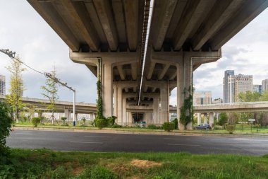 Şehirdeki üst geçidin altında beton yapı ve asfalt yol alanı