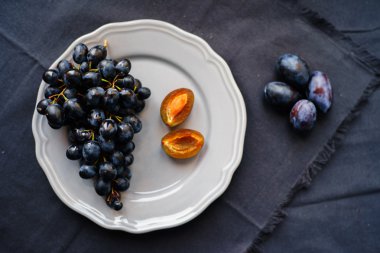 siyah üzüm ve Erik bir plaka üzerinde