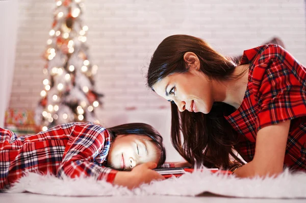 Anne ve kızı Noel ağacının yanında yeni yıl hediyelerini bekliyor..