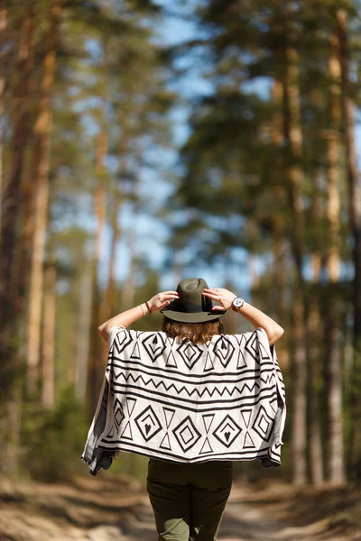 La chica va a un callejón del bosque vestida con poncho indio . — Foto de Stock