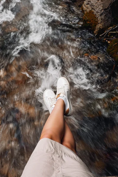 La niña fotografió sus pies en el fondo de un río de montaña . — Foto de Stock
