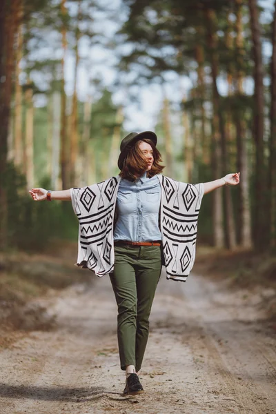 Chica en un sombrero camina a través del bosque de otoño — Foto de Stock