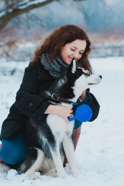 Mujer joven con perro husky en el parque de invierno — Foto de Stock