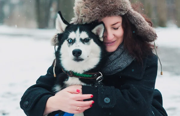 Mujer joven con perro husky en el parque de invierno Fotos De Stock