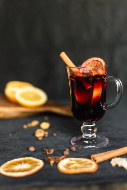 Noel aromalı kırmızı şarap ve narenciye meyveleri yakın planda. Geleneksel sıcak içecek Noel zamanı