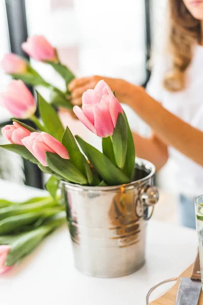 A large bouquet of pink tulips in a champagne bucket. Bouquet in a vase. Spring mood. Gift for International Womans Day or Spring.