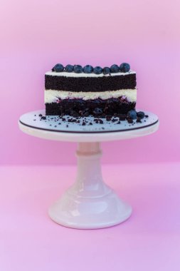 Peynir kremalı çikolatalı kek. Yaban mersiniyle süslenmiş. Lezzetli düğün pastası. Pembe izole bir arka planda kek. Yüksek kalite fotoğraf