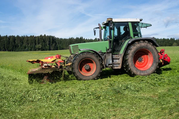 Traktor slåtter gröna äng — Stockfoto