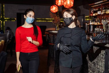 Yeni normal. Coronavirus pandemia covid-19 sırasında kafeleri ve restoranları ziyaret etmek için yeni kurallar. Müşterilerle iletişim sırasında maksimum koruma - çalışanlar için maske ve eldiven.