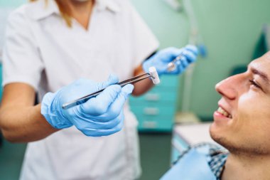 Tıbbi aletlerle dişçinin ellerini yakın plan çek. Büyük ayrıntı, dişçinin aynası, kıvrılma ve sonda. Diş sorunlarının çözümü kendinden emin, profesyonel jestlerle etkili.