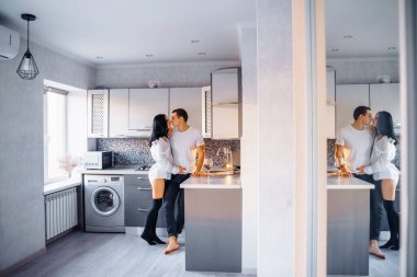 Çıplak, tutkulu bir öpüşme çifti. Adam ve kadın samimi seks yapıyor. Genç aşıkların erotik anları. Ateşli bebek sevgilisini nazikçe öpüyor, mutfak mobilyasına yaslanıyor. 14 Şubat 'ta..