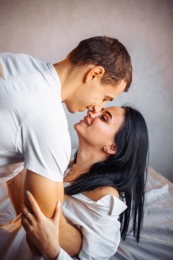 Seksi bir adam tutkuyla kız arkadaşını nazikçe yatağa itti. Kadına büyük zevk vermeye hazır. Aşıklar yatakta tutkulu olurlar. Genç çift oturma odasında yakınlaşıyor..