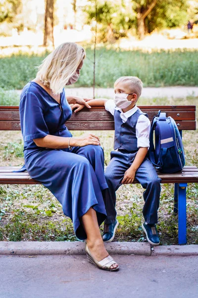 어머니 와아들은 학교에 다니는 아들과 마당에 벤치에 있습니다 그들은 코로나 — 스톡 사진