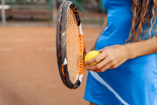 A close-up shot of a tennis ball and racket. The tennis player prepares to serve during the match. A beautiful sport that requires physical, emotional and mental preparation.