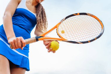 Tenis topu ve raketin yakın plan çekimi. Tenisçi maç sırasında servis yapmaya hazırlanıyor. Fiziksel, duygusal ve zihinsel hazırlık gerektiren güzel bir spor..