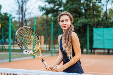 Saha merkezinde hızlı bir hamle. İnternette kısa hareketler deniyorum. Turuncu kil tenis kortunda aktif bir tenis oyunu. Koçun temiz, doğru atışları.