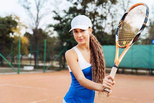 カメラを覗き込む 美しい ヨーロッパの女性は自信を持ってトレーニング中にテニスコートでボールを打つ 勝つことを決めた スタイリッシュなスポーツテニスの制服に身を包んだ ドレス — ストック写真