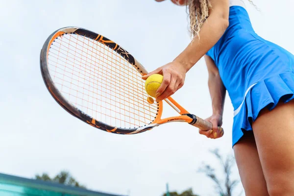 A close-up shot of a tennis ball and racket. The tennis player prepares to serve during the match. A beautiful sport that requires physical, emotional and mental preparation.