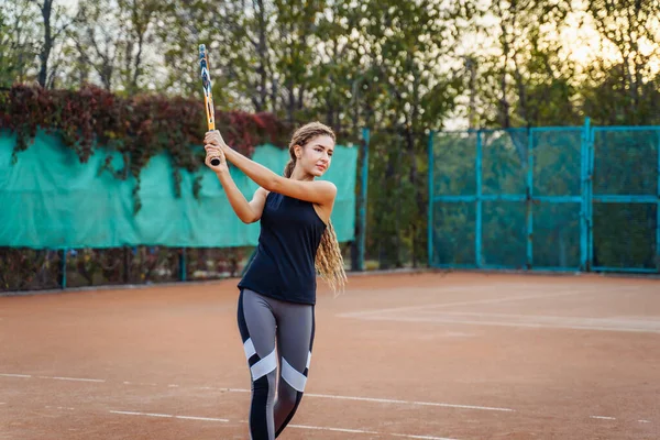 プロのテニス選手がコートでスポーツをしている 彼女はラケットで 空気中で一時停止し ボールを打つしようとしています テニス選手が活躍中 試合に勝つには多くのエネルギーと力が必要です — ストック写真