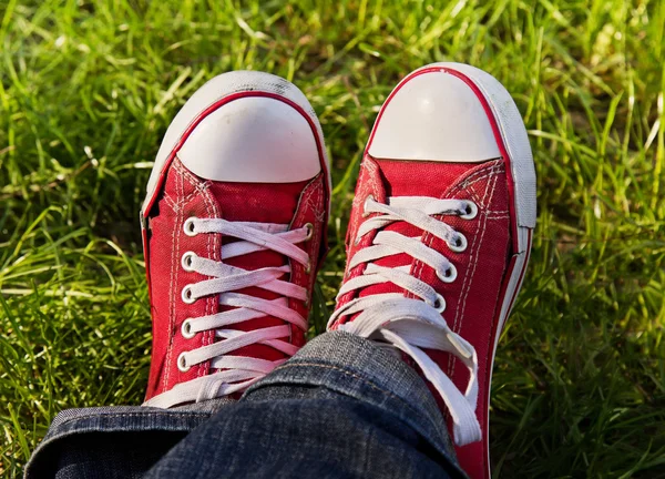 Feet in dirty red sneakers outdoors. — Stock Photo, Image