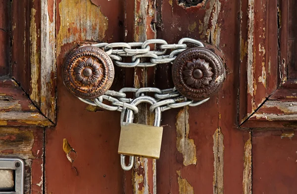 Old grungy wooden door with peeling paint and round door-handles — Stock Photo, Image