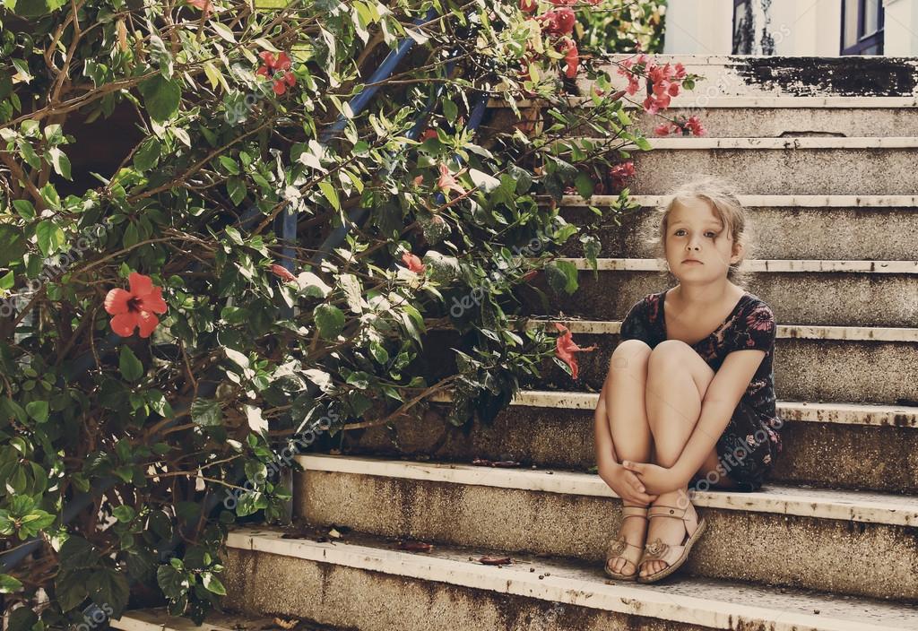 Nettes kleines Mädchen sitzt auf der Treppe Stockfotografie