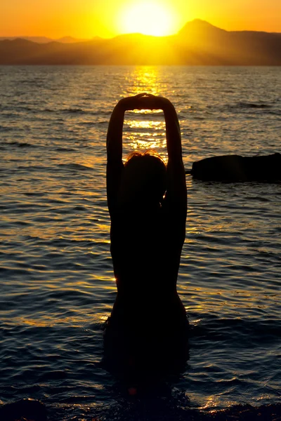 Jonge vrouw is het beoefenen van yoga bij zonsondergang — Stockfoto