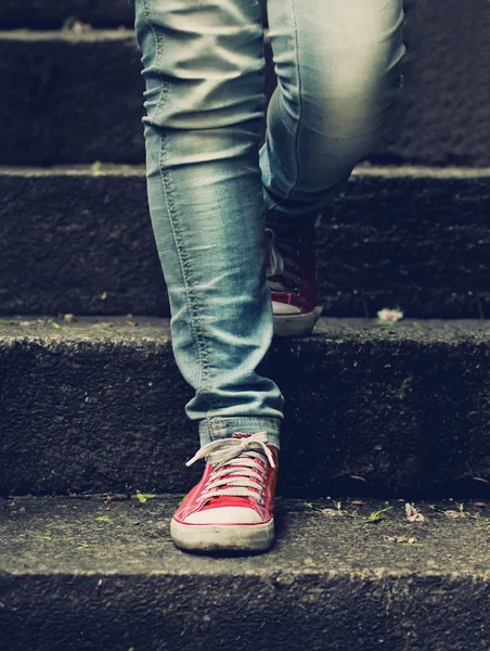 küçük kız kırmızı spor ayakkabılar ve kot merdivende daimi