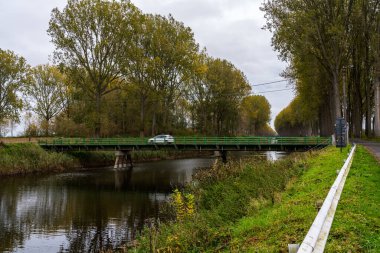Güzel bir sonbahar gününde nehir boyunca bir köprü ve bir sürü ağaç.