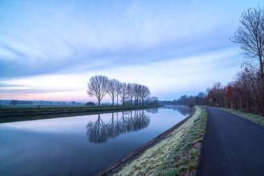 Nehir boyunca uzanan bu manzara, sonbahar boyunca sabah erken saatlerde yükselen güneşle birlikte biraz sis ile birlikte.