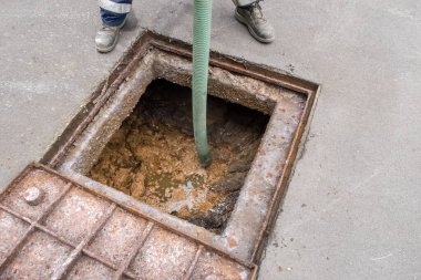 Temizleme servisi lağım çukurunu kalın bir bağırsakla temizliyor.