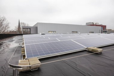 Yerleşim alanındaki bir binada bulutlu bir günde çatıda güneş panelleri vardır.