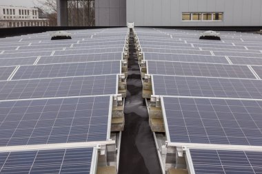 Yerleşim alanındaki bir binada bulutlu bir günde çatıda güneş panelleri vardır.