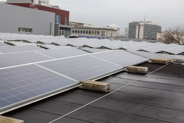 on an building in an residential area, there are solar panels on the roof on a cloudy day