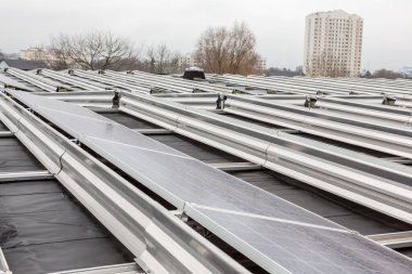 Yerleşim alanındaki bir binada bulutlu bir günde çatıda güneş panelleri vardır.