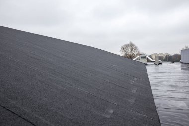 Büyük bir spor salonunda çatısı olan eğimli bir çatı var.