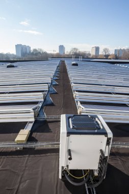 Yerleşim alanındaki bir binada bulutlu bir günde çatıda güneş panelleri vardır.