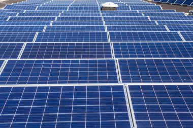 Konut alanındaki bir binada güneşli bir günde çatıda güneş panelleri var.