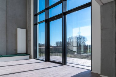 Yüksek bir pencerenin yanındaki beton duvarda radyatör olan büyük bir dinlenme odasında.