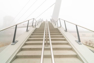 Kayıp bir sabahta bisiklet yaya köprüsü için beton bir merdiven.