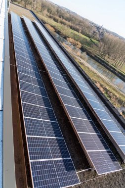 Konut alanındaki bir binada güneşli bir günde çatıda güneş panelleri var.