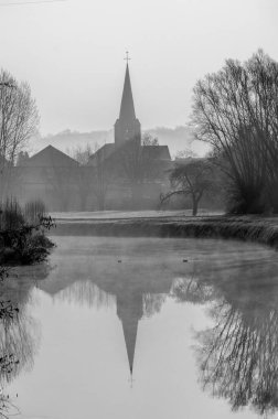 Sabah sisli bir nehirde, arkasında güzel bir kilise var.