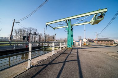 Güneşli bir sabahta nehir boyunca uzanan bu güzel asma köprü kapalı.