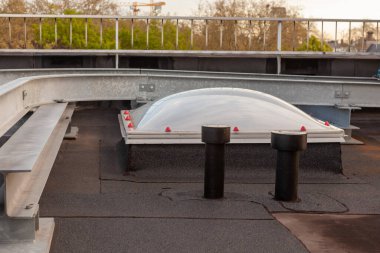 Şehrin göbeğindeki büyük bir binanın çatısındaki plastik ev.