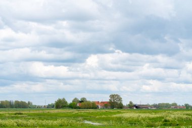 Çok bulutlu karanlık bir günde tarlada güzel bir ev var.