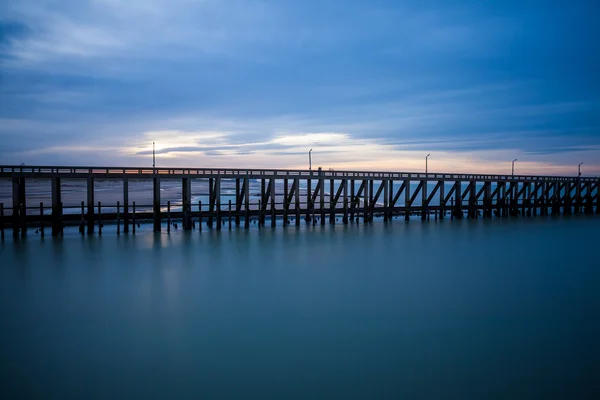 De pier whit lichte stok op de zee — Stockfoto