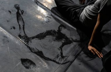 Siyah dans pistinde ıslak dansçı vücudu.